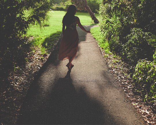 Woman-walking-down-pathway