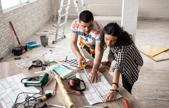 Couple making home improvement, measuring, high angle view.