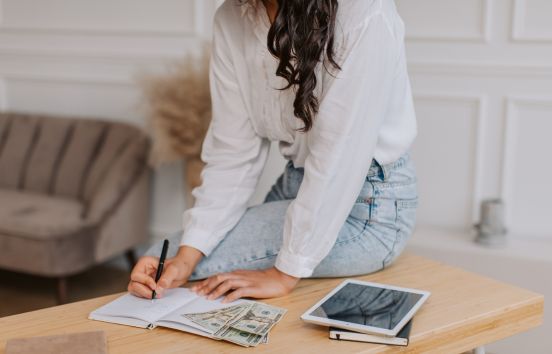 Woman sitting on desk using budgeting tools