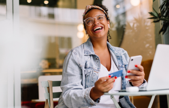 Woman at cafe table shopping online with credit card