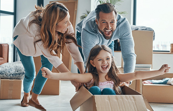 Family of 3 having fun with boxes while moving into new house