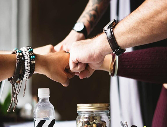 Several hands doing fist bump