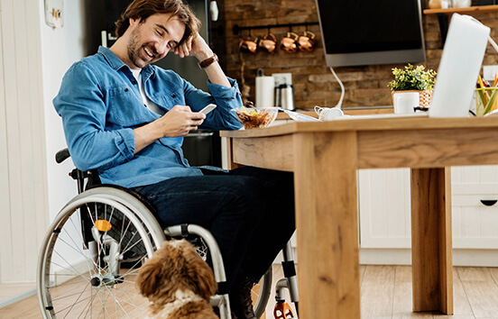 Man in wheelchair looking at mobile phone