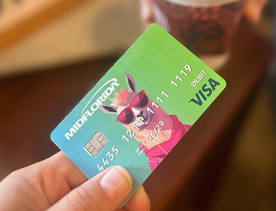 hand holding llama debit card buying coffee