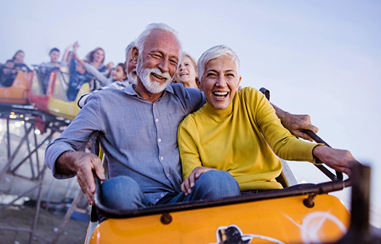 Older couple having fun on fair roller coaster