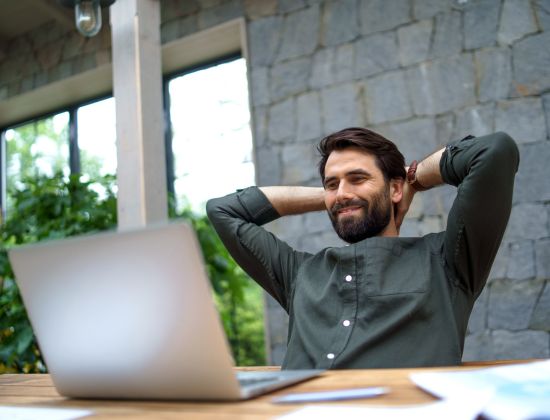 Man with beard relaxed working on laptop. 
