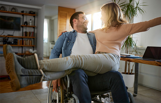 Couple in home celebrating, man is in wheelchair