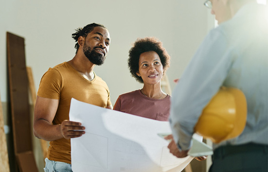 Couple with contractor working on house plans