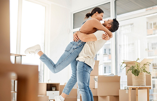 Couple hugging in new home with boxes surrounding