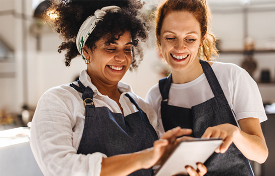 Two women business owners on tablet looking at accounts through Treasury Management