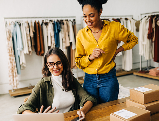 Two women business owners looking at their Checking plus interest account