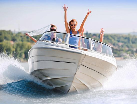 Group of young people with raised hands enjoying in a speedboat ride.