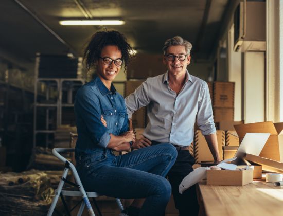 Male and female business owners standing together in workshop.
