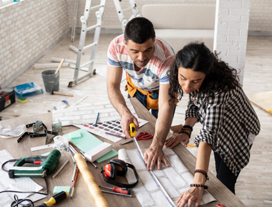 Couple making home improvement, measuring, high angle view.