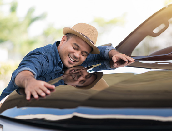 Young handsome Asian man getting the new car. He hugged his car and was very happy.