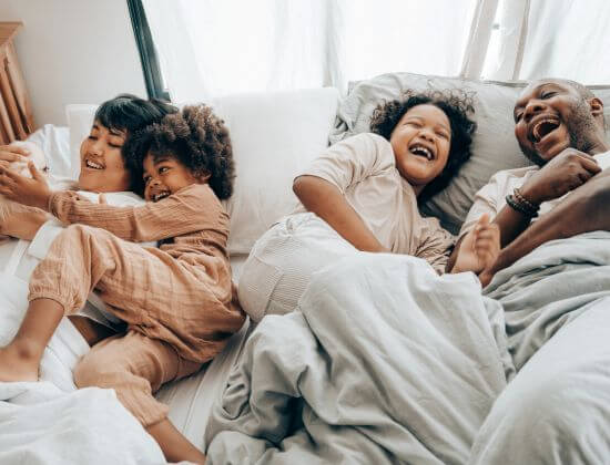 Kids laughing in parents' bed