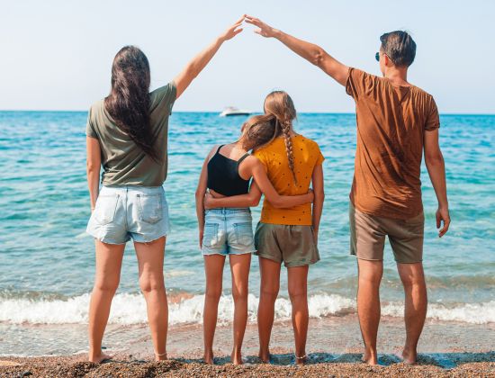 Family on beach vacation looking out at ocean