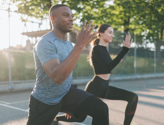 Couple exercising outside on court