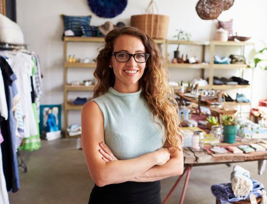 Young female business owner standing in small boutique.