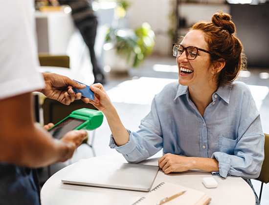 Woman paying for her meal at cafe with her Visa Signature credit card