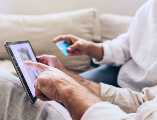 Couple on couch making a balance transfer on the new MIDFLORIDA Visa Platinum