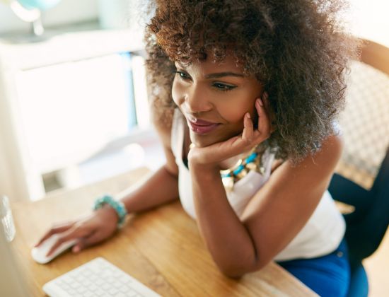 Female business owner at computer looking over her extreme savings account with online banking