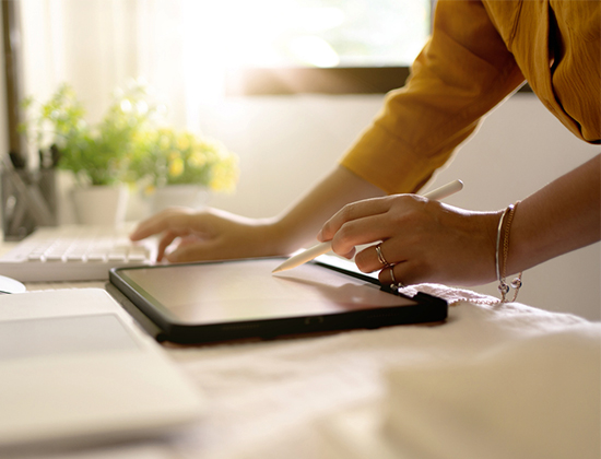 Female hands with tablet and pen looking at external accounts.
