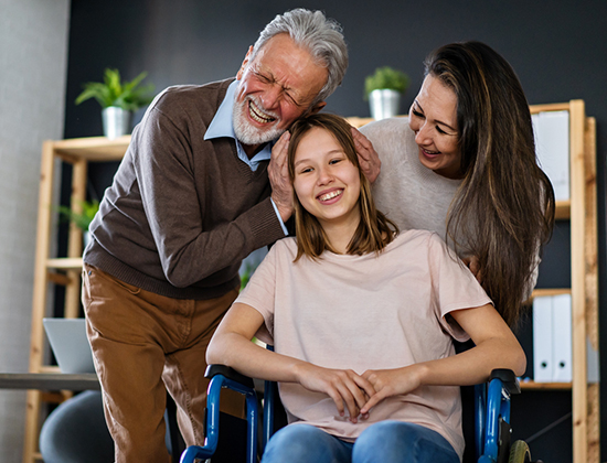 Family laughing with daughter in wheelchair