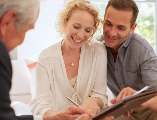 Couple signing papers with a financial advisor
