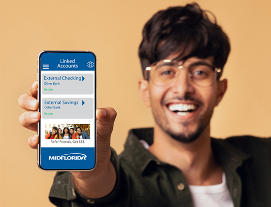 Young man holding mobile phone out to see linked account options