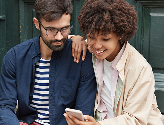 Mixed race couple watching funny video