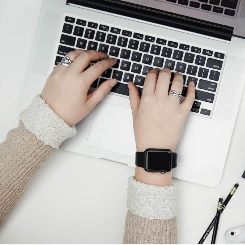 Person's hands typing on laptop