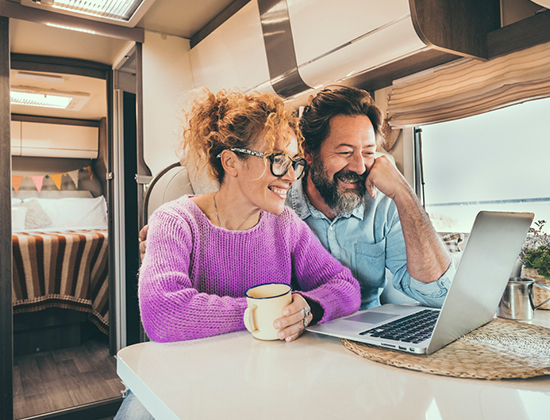 Retired couple on laptop in their RV