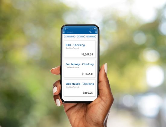Hand holding cell phone displaying multiple account through mobile banking.