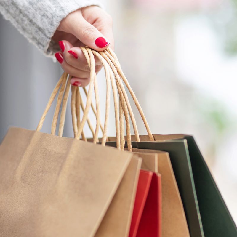 Female hand holding several holiday shopping bags