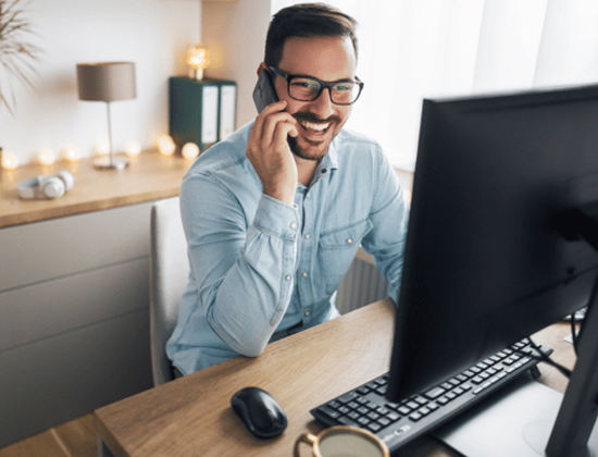 Man at desk on phone at computer