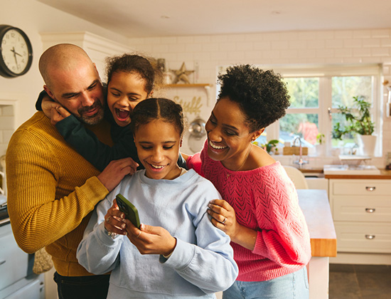 Teen girl looking at account on phone with family