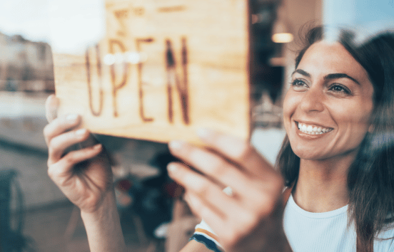 Business owner changing her sign to say "Open."
