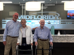 Two elderly MIDFLORIDA credit union customers with an employee posing at the Stuart branch