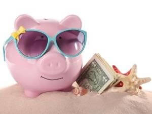 A piggy bank wearing sunglasses, dollar bills and a seashell