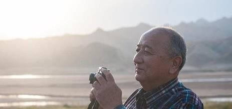 Retired man taking a photo on vacation.